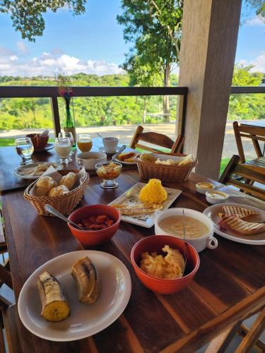 un tavolo in legno ricoperto di ciotole e piatti di cibo di Hotel Fazenda sol nascente a Pau dʼAlho