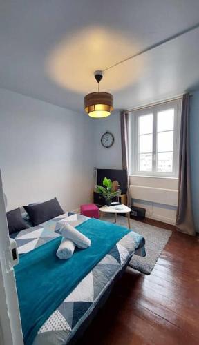 une chambre avec un lit bleu et une fenêtre dans l'établissement Entre Ciel et Quai Duplex avec vue, à Dieppe