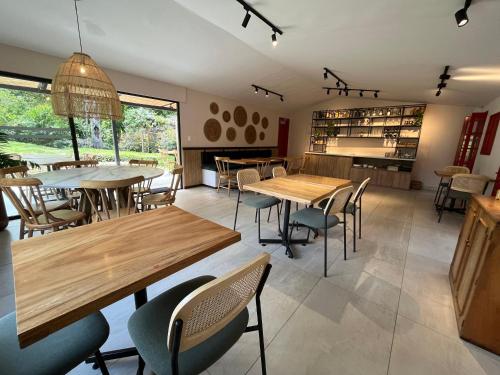 uma sala de jantar com mesas e cadeiras de madeira em La Cabaña Ecohotel - Valle del Cocora em Salento