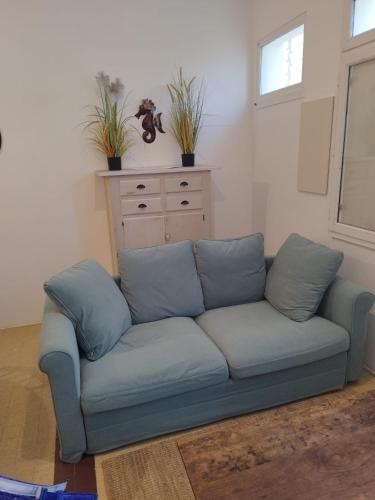 a blue couch in a living room with two pillows at DU SEMAPHORE in Fouras