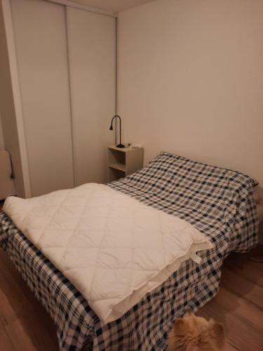 a bedroom with a bed with a checkered blanket at DU SEMAPHORE in Fouras