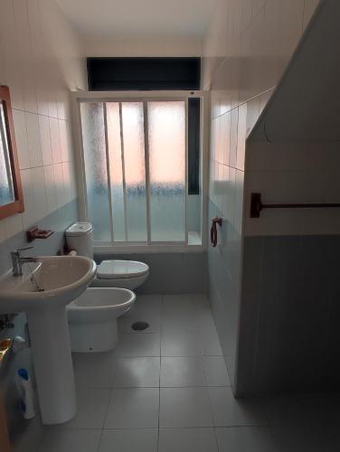 uma casa de banho com 2 WC, um lavatório e uma janela em Precioso apartamento con vistas em Posada de Llanes