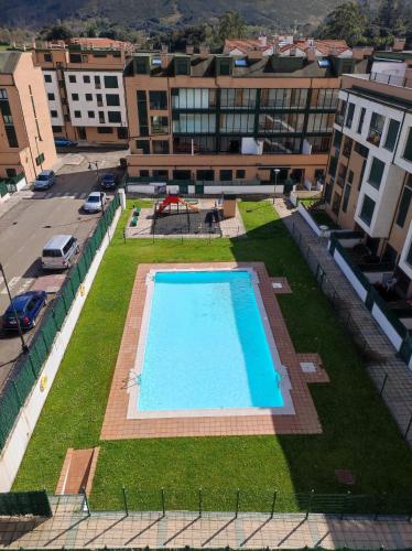 uma vista superior de uma piscina numa cidade em Precioso apartamento con vistas em Posada de Llanes