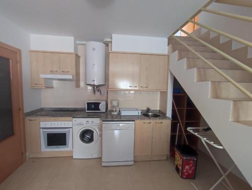uma pequena cozinha com uma máquina de lavar roupa e uma escada em Precioso apartamento con vistas em Posada de Llanes