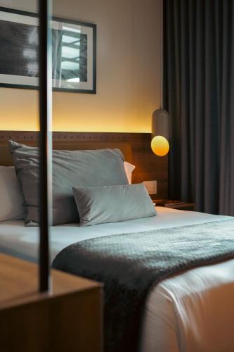 a hotel room with a bed and a lamp at Hotel Sexto by Icono in Armenia