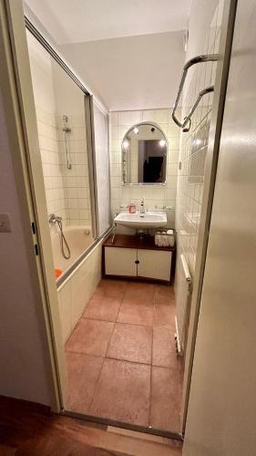 uma casa de banho com uma banheira, um lavatório e um espelho. em Vienna cozy & lovely Apartment em Viena