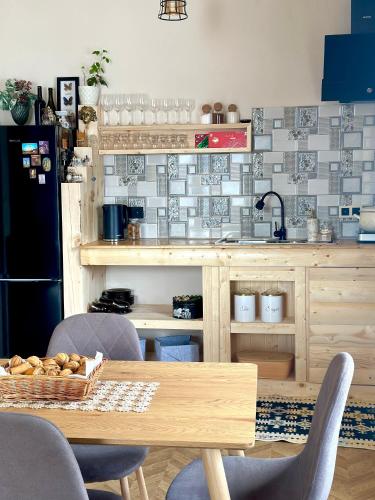a kitchen with a table and some chairs and a refrigerator at In The Forest in Mestia