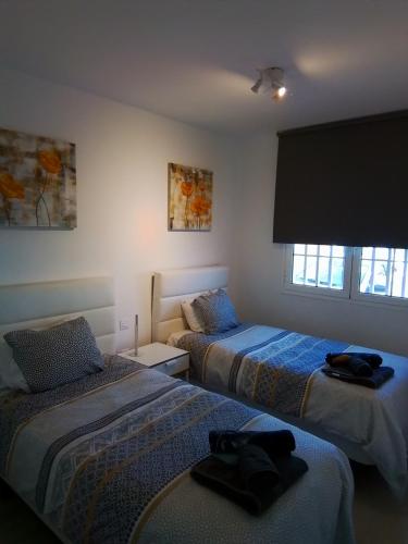 a bedroom with two beds and a window at Atlantic View 6B in Puerto del Carmen