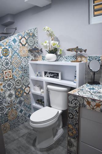 a bathroom with a toilet and tiles on the wall at Hotel Boutique Calizo vip in Fajardo