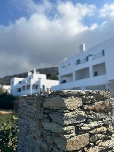 a stone wall with a building in the background at Aegean Mirror, Andros in Apróvaton