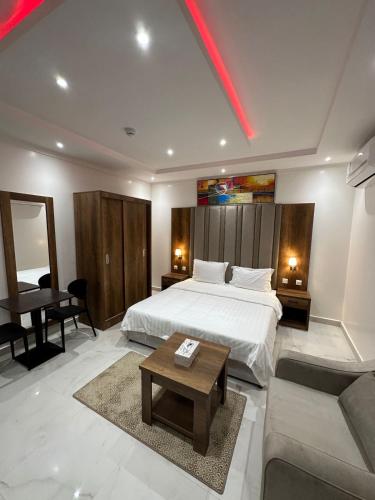 a bedroom with a bed and a couch and a table at ليوان الريان للشقق المخدومة Liwan Al-Rayyan for serviced apartments in Riyadh