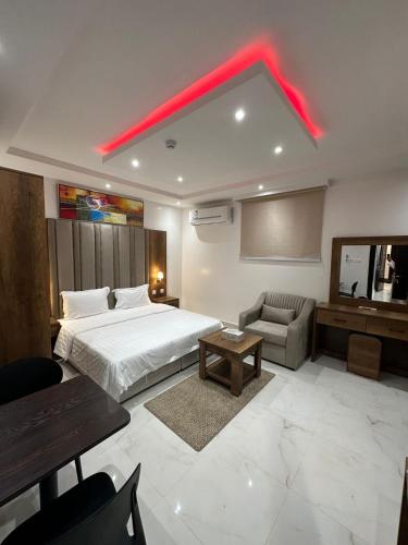 リヤドにあるليوان الريان للشقق المخدومة Liwan Al-Rayyan for serviced apartmentsのベッドと赤いライト付きのホテルルーム