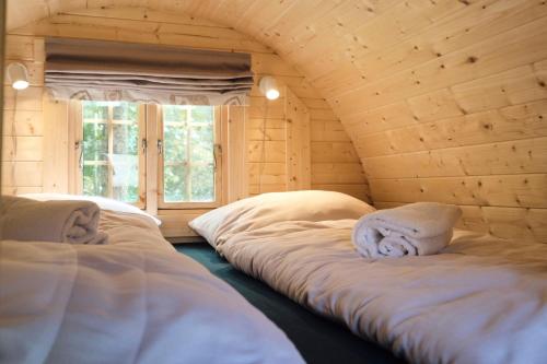 a room with three beds in a wooden room at Hygge Ho - mitten in der Natur mit Sauna und Spa in Blåvand