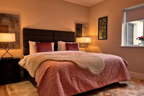 a bedroom with a large bed and two lamps at Modern country charm apartment. in Mullingar
