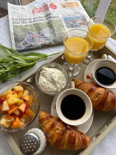Saint-PellerinにあるGîte Gold au Domaine de Saint Vigorの朝食用のコーヒーとクロワッサンのトレイ