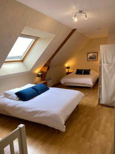 1 dormitorio en el ático con 2 camas y ventana en Gîte Gold au Domaine de Saint Vigor 