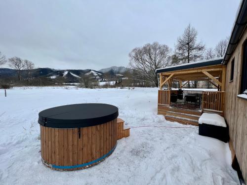 a wooden cabin with a snow covered yard at Domček pod Vežami s vírivkou a grilom, pri termálnom kúpalisku in Liptovský Ján