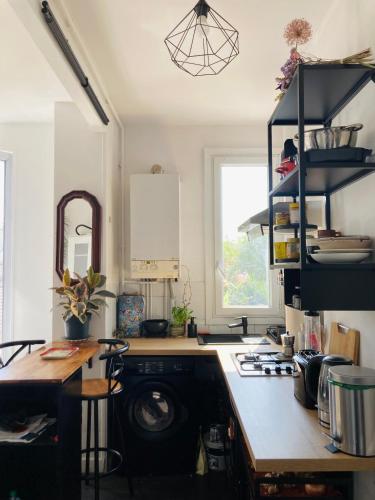 une cuisine avec un évier et une cuisinière four supérieur dans l'établissement APPARTEMENT AU COEUR DES JEUX OLYMPIQUES., à LʼÎle-Saint-Denis