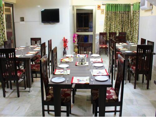 a dining room with tables and chairs and a television at Rajeshwari Resort in Udaipur