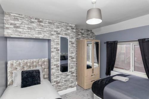 a bedroom with two beds and a brick wall at Town Centre Town House free WiFi and free on street parking in Middlesbrough