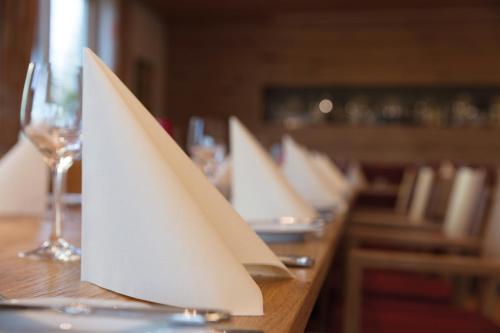a row of white napkins on a wooden table at Landhotel Steigenhaus in Untermünkheim