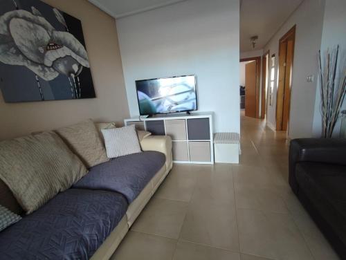 un soggiorno con divano e TV a schermo piatto di Hacienda Riquelme Golf Resort Ground Floor Apartment Sucina Murcia a Murcia