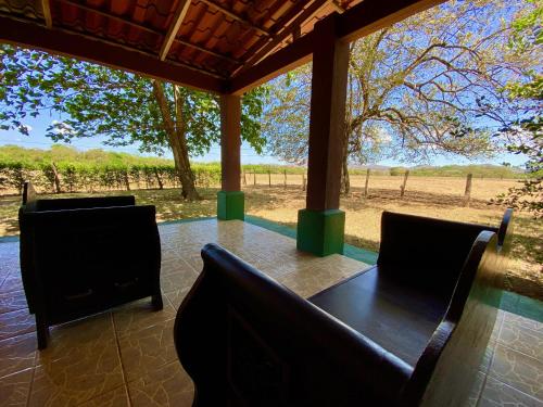 Cartagena的住宿－Casa Pochotal，享有田野景致的门廊上的桌椅