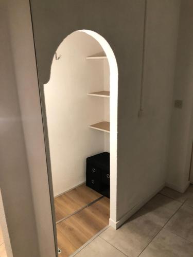 an archway in a room with a mirror at Studio Rez de chaussée in Beaurepaire