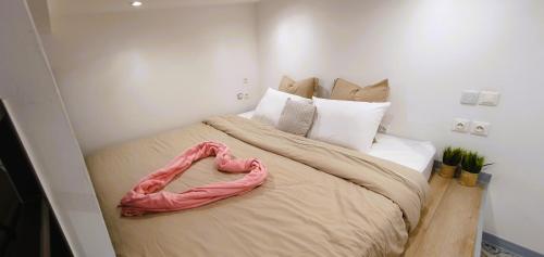 un grande letto con un cuore rosa sopra di Studio pour jusqu'à 4 personnes proche de l'hôpital et du centre ville a Saint-Denis