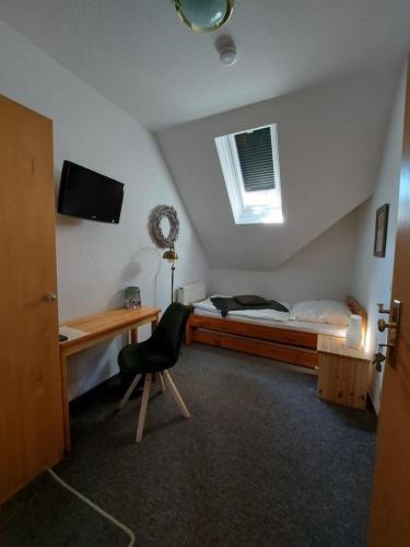 a bedroom with a bed and a desk and a chair at Am Wasserturm Pension in Bad Muskau