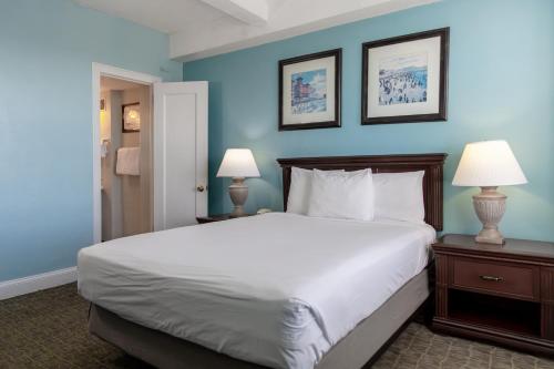 1 dormitorio con 1 cama blanca grande y paredes azules en Legacy Vacation Resorts - Brigantine Beach, en Brigantine