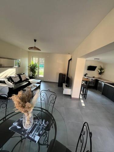 un salon avec un canapé, une table et des chaises dans l'établissement Maison au bord de rivière, à Gissey-sur-Ouche