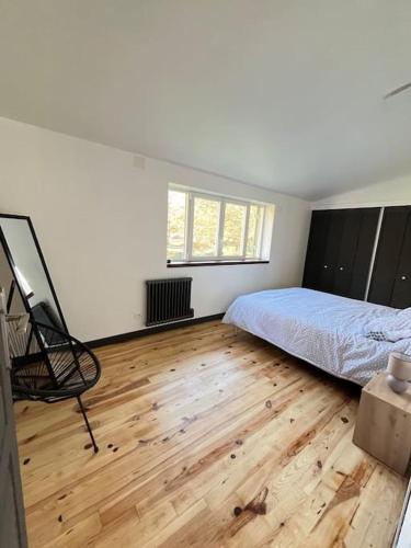 une chambre avec un lit et un parquet dans l'établissement Maison au bord de rivière, à Gissey-sur-Ouche