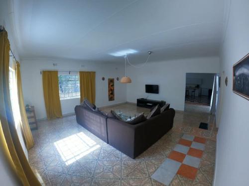 una sala de estar con un sofá y una mesa en Jacobsen Bungalow in Maun, Boronyane, en Maun