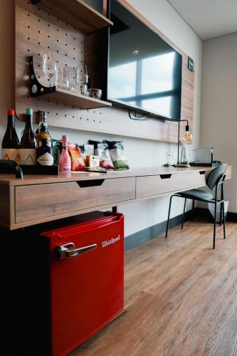 a kitchen with a counter with a red cooler at Hotel Sexto by Icono in Armenia