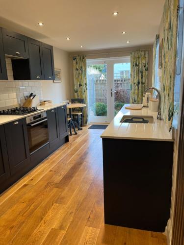 a kitchen with black cabinets and a wooden floor at 2 bedroom cottage in Stamford in Lincolnshire