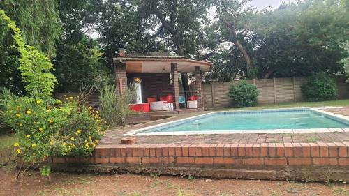 a swimming pool with a gazebo in a yard at Secret Guest House in Pietermaritzburg