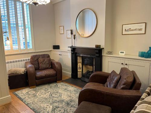 a living room with two chairs and a fireplace at 2 bedroom cottage in Stamford in Lincolnshire