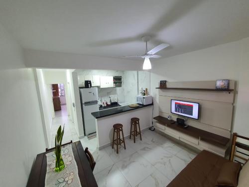 a living room with a kitchen and a table with chairs at Apartamento em Peruíbe (Centro) in Peruíbe