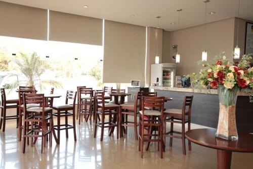 un restaurante con mesas y sillas de madera y una barra en Samba Três Lagoas, en Três Lagoas