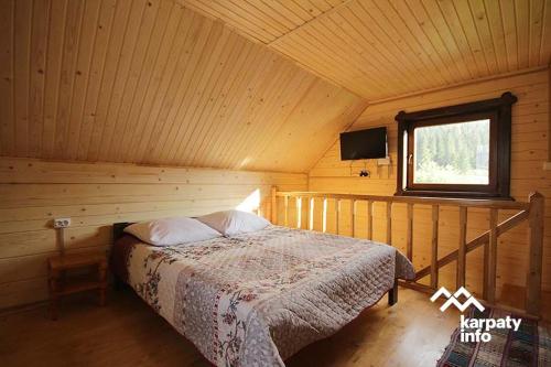um quarto com uma cama num chalé de madeira em Орхідея Luxe em Synevyrsʼka Polyana