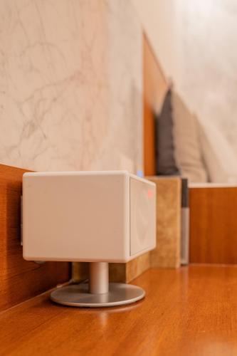 a white speaker sitting on top of a wooden table at Gangnam Boutique Hotel Sohsul in Seoul