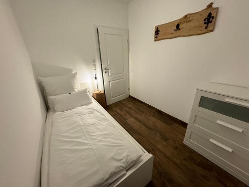 Dormitorio pequeño con cama y vestidor en Ferienhaus Wintermoor Ganzer Bungalow, en Schneverdingen
