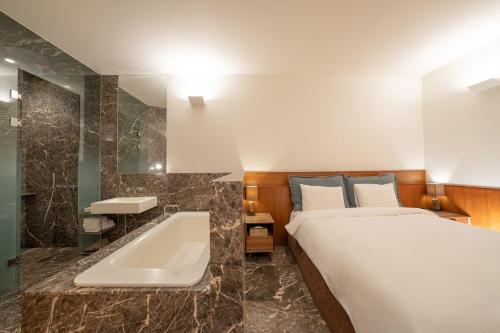 a bedroom with a bed and a tub and a sink at Gangnam Boutique Hotel Sohsul in Seoul