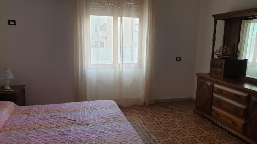 a bedroom with a bed and a dresser and a window at Bingo 1 completo in Alghero