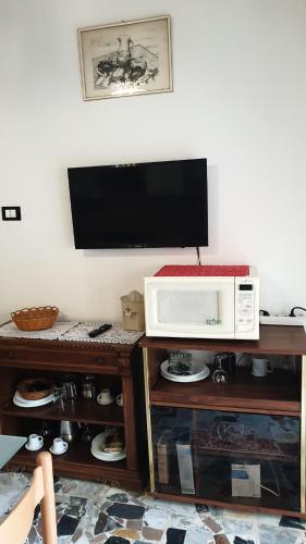 a microwave oven sitting on a stand next to a wall at Bingo 1 completo in Alghero
