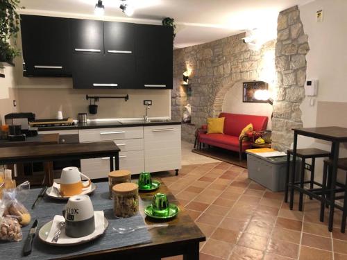 een keuken en een woonkamer met een tafel met hoeden erop bij BB Diesis in Ferrazzano