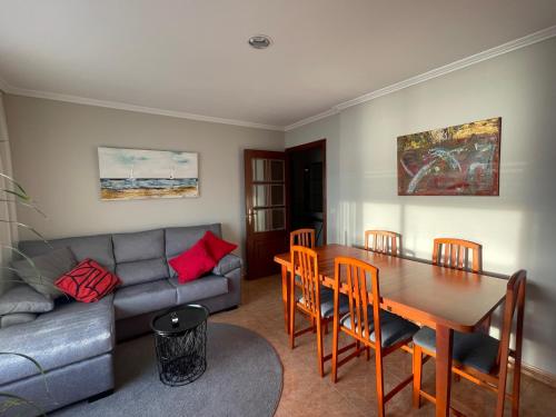 uma sala de estar com uma mesa e um sofá em Piso Vacaciones en el mar em Sanxenxo