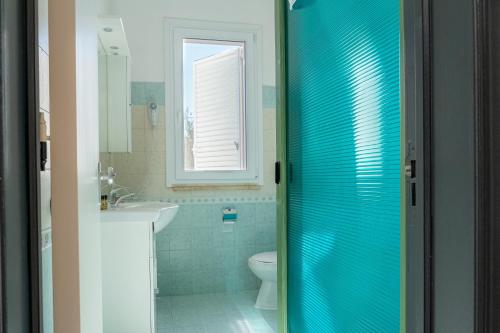 a bathroom with a toilet and a glass shower door at Hotel Le Macine in Santa Cesarea Terme