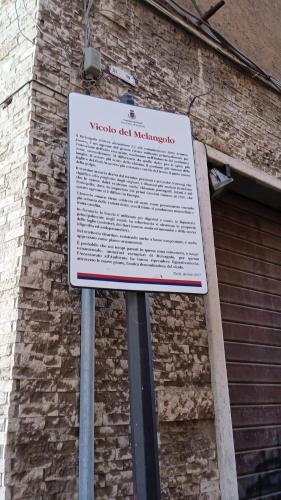 a sign in front of a brick building at La casa sui tetti in Tivoli